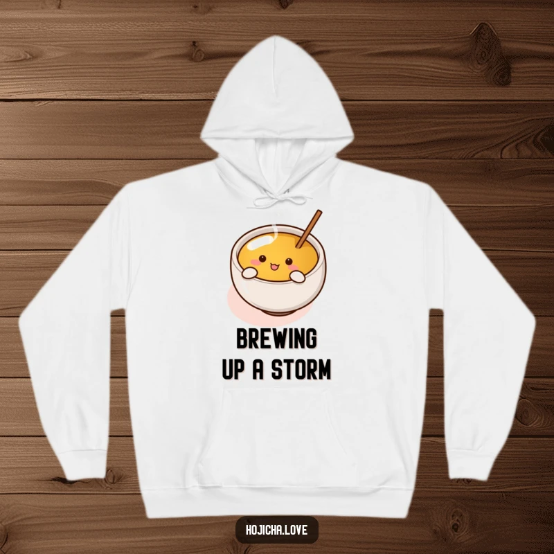 Funny hojicha cup with tiny arms enthusiastically stirring tea, printed on a soft, warm, and humorous hoodie.